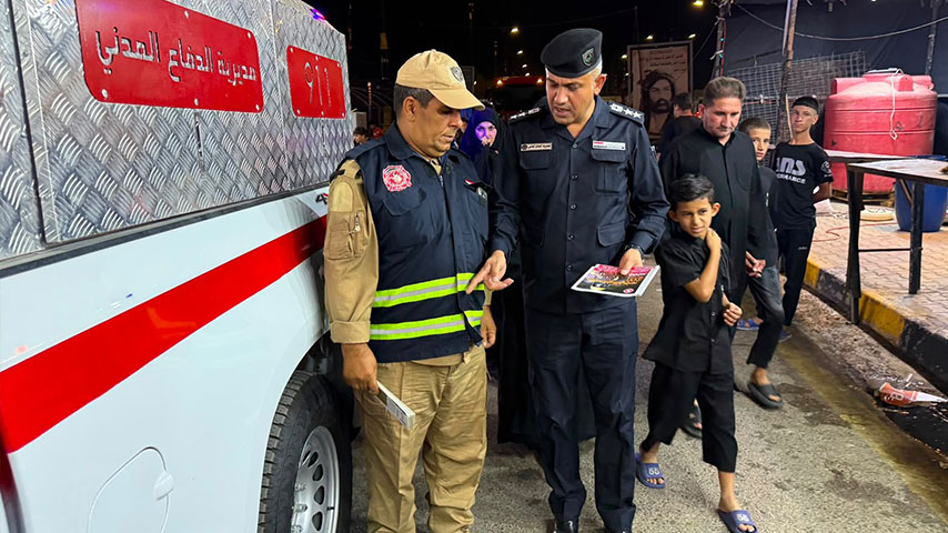 فرق الدفاع المدني العراقية تقف بجانب سيارات الإطفاء في أحد شوارع النجف الأشرف.