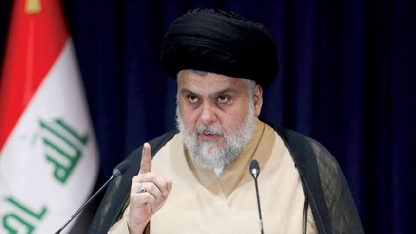السيد مقتدى الصدر يلقي كلمة في مؤتمر صحفي وأمامه علم العراق.